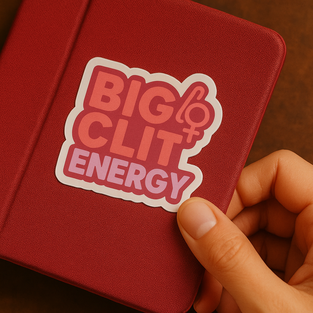 Red notebook with a 'BIG CLIT ENERGY' sticker held by a hand
