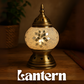 Decorative lantern with intricate design on a wooden surface, brand 'Lantern' visible.