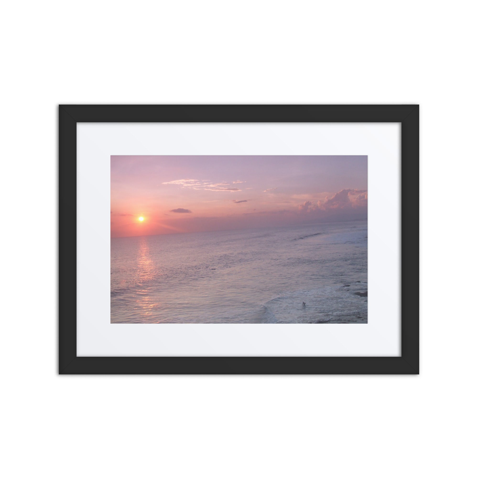 Framed artwork of a sunset over the ocean with a black frame.
