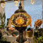 Golden Star Turkish Mosaic Lamp glowing warmly, showcasing its handcrafted amber and burgundy glass design.
