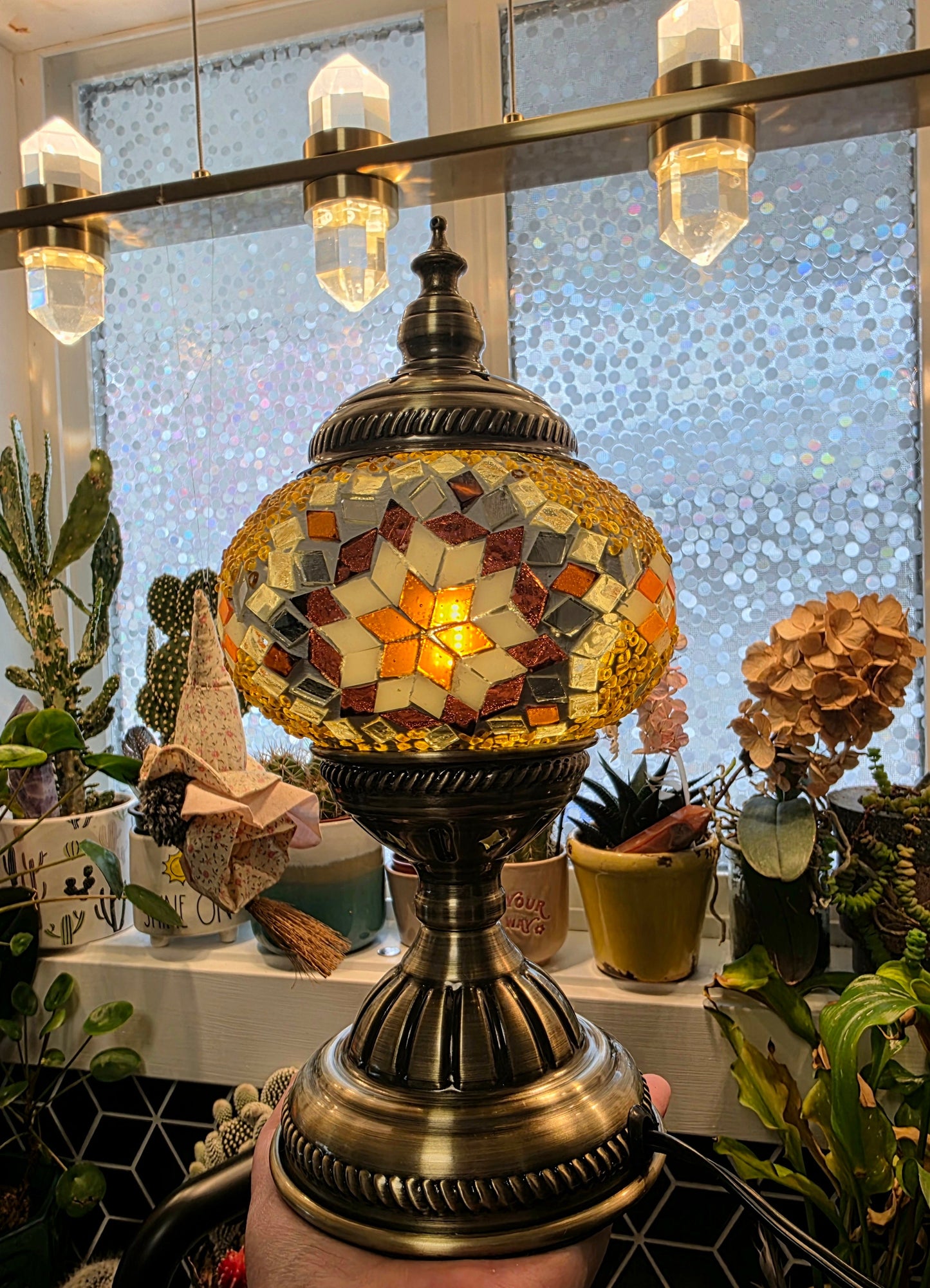 Golden Star Turkish Mosaic Lamp glowing warmly, showcasing its handcrafted amber and burgundy glass design.