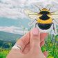 Close-up view of the Save The Bees Sticker showcasing its die-cut design and matte finish, highlighting the vibrant colors ideal for indoor and outdoor use.